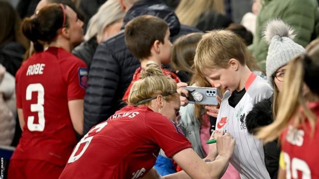 Liverpool's Jasmine Matthews signs a fan's shirt after the Women's Super League game against Everton at Goodison Park