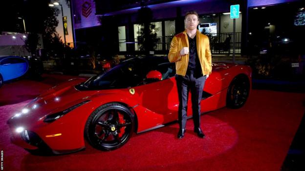 Saul 'Canelo' Alvarez poses next to a Ferrari