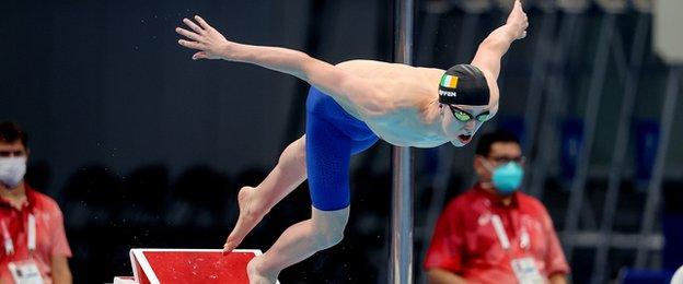 Daniel Wiffen dives into the pool as he wins his 1500m freestyle heat in Tokyo