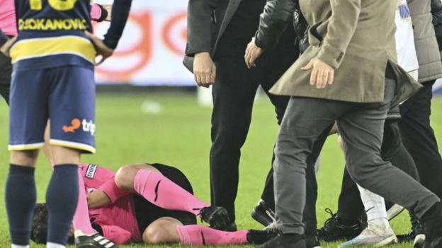 Referee Halil Umut Meler falls to the ground