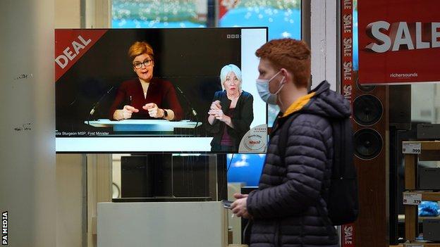 A shopper watches Nicola Sturgeon's speech