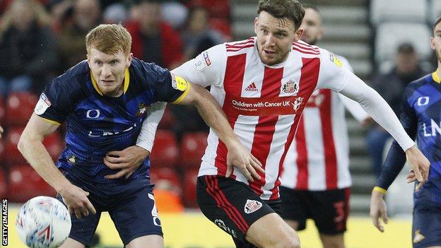 Brad Halliday of Doncaster takes on Charlie Wyke of Sunderland