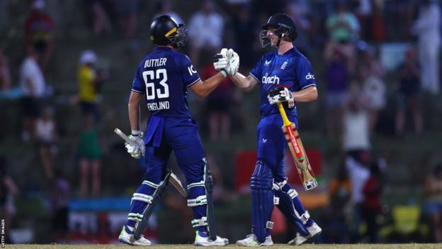 Jos Buttler (izquierda) y Harry Brook (derecha) celebran las carreras ganadoras contra las Indias Occidentales en el segundo ODI.