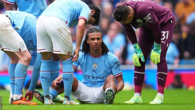 Nathan Ake sits injured on the ground during Manchester City's win against Leeds United