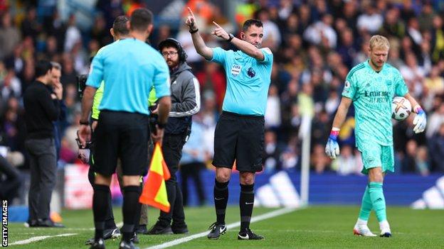 Referee Chris Kavanagh gestures to the Leeds and Arsenal players to leave the Elland Road pitch