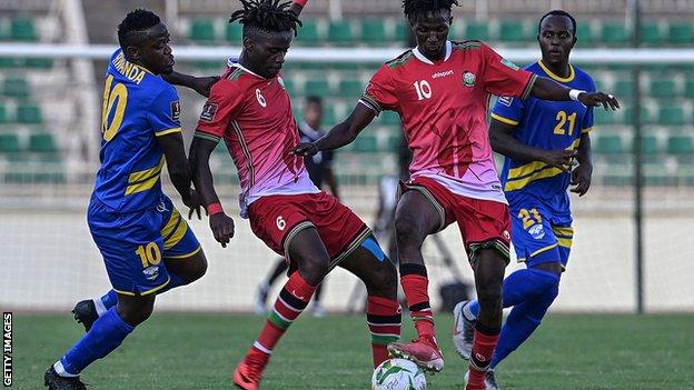 Kenya midfielders Richard Odada and Kenneth Muguna fight for the ball with Rwanda midfielder Muhadjiri Hakizimana
