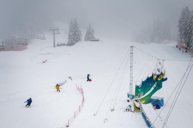 Les officiels franchissent le parcours du championnat alpin à Cortina après que de fortes chutes de neige aient retardé la compétition.