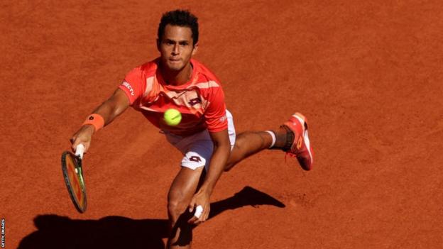 Juan Pablo Varillas stretches for a ball in his French Open match against Novak Djokovic