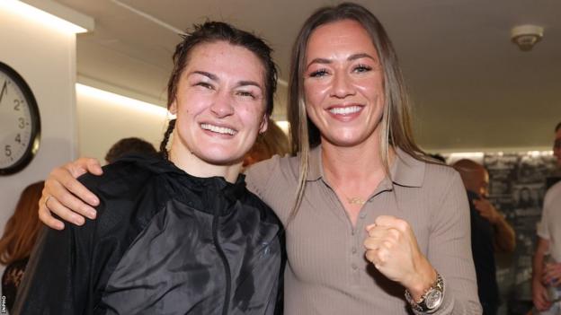 Katie Taylor (left) with Katie McCabe after successfully defending her undisputed lightweight world championship belts in October