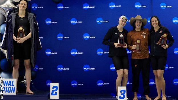 Transgender woman Lia Thomas (L) of the University of Pennsylvania stands on the podium after winning the 500-meter freestyle as other medalists (LR) Emma Weyant, Erica Sullivan and Brooke Forde pose for a photo. Photo.