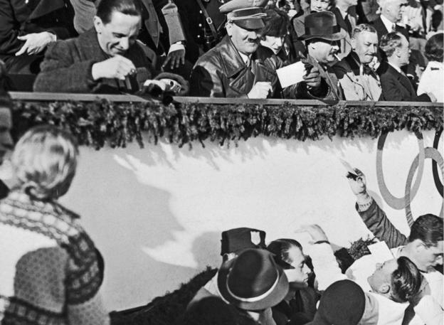 Propaganda curate  Joseph Goebbels (seated apical  left) and Nazi person  Adolf Hitler (next right) astatine  the Winter Olympics closing ceremony