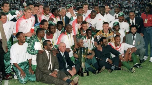 South Africa players and staff celebrate winning the 1996 Africa Cup of Nations with politicians FW de Klerk and Nelson Mandela and King Goodwill Zwelithini