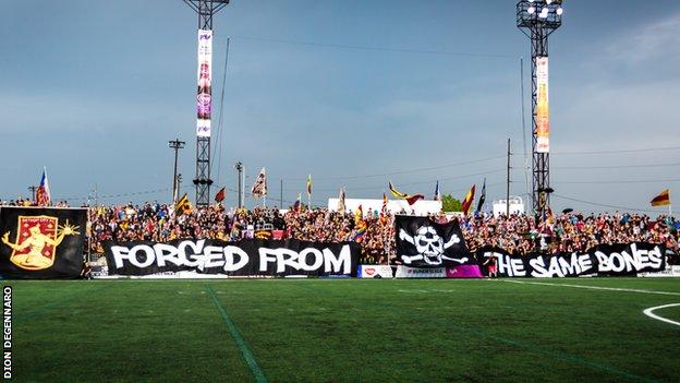 Detroit City fans unveil a banner that reads: Forged from the same bones