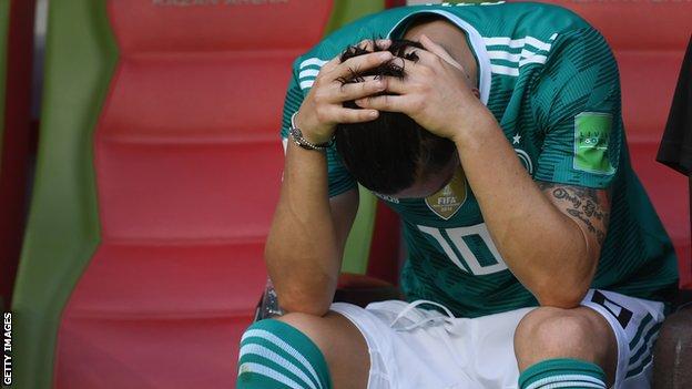 Mesut Ozil holds his head in his hands