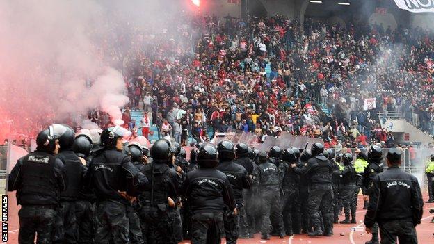 Tunisian policemen stand guard as fans throw flares during February's match between Esperance and Club Africain