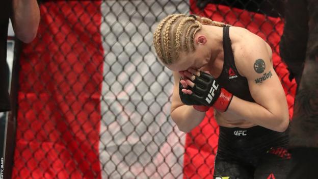 Valentina Shevchenko bows in front of the flag of Peru