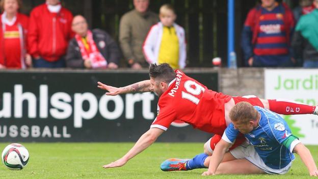 Cliftonville's Ciaran Murray goes down as David Armstrong of Dungannon Swifts challenges at Stangmore Park