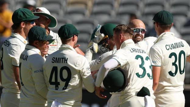 Nathan Lyon is congratulated by his Australia teammates after taking his 500th career Test wicket against Pakistan in Perth