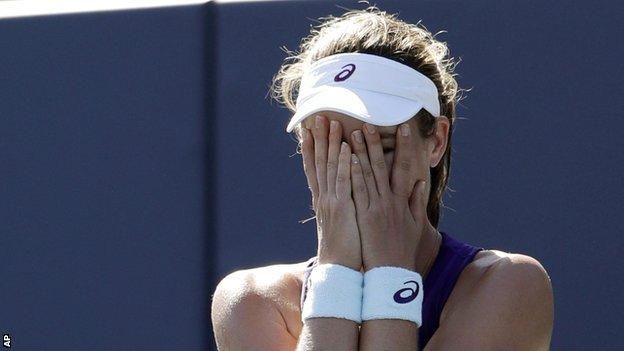 Johanna Konta covers her face with her hands after winning her first WTA title