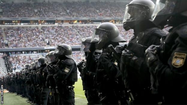 Riot police line up to face fans at the Allianz Arena