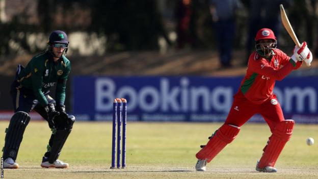 Aaqib Ilyas in action for Oman as Ireland wicket-keeper Lorcan Tucker looks on
