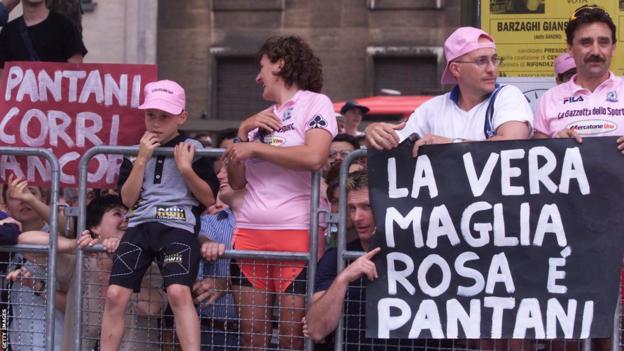 Italian fans down  a barrier, 1  carrying a motion   claiming that 'Pantani is the existent   maglia rosa' (pink jersey)