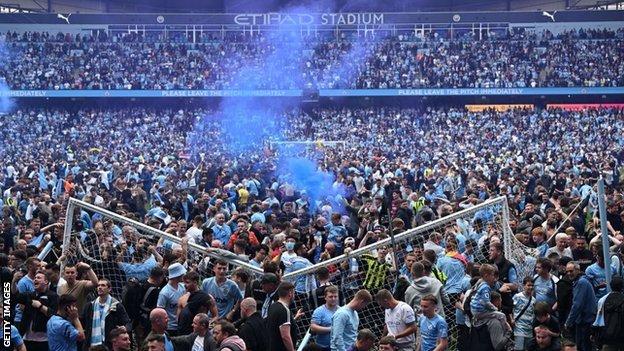 Man City fans invade the pitch at Etihad Stadium after the final game of the season