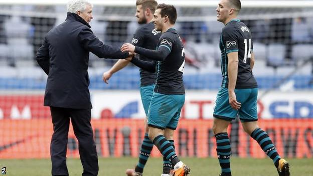 Mark Hughes celebrates with players