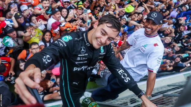 George Russell and Lewis Hamilton pose in front of the crowd