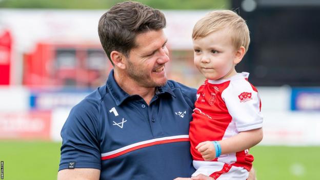 Lachlan Coote cuddles his son
