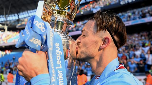 Jack Grealish kisses the Premier League trophy aft  Manchester City are confirmed 2022-23 champions