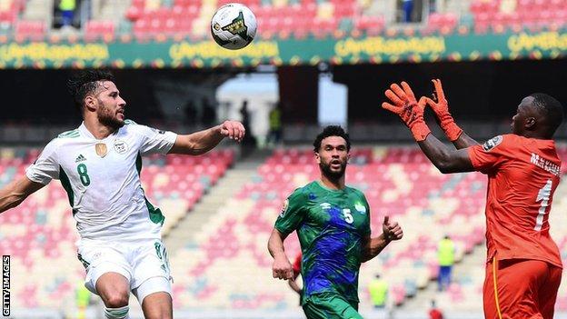 Algeria forward Youcef Belaili (left) fights for the ball with Sierra Leone's goalkeeper Mohamed Nbalie Kamara