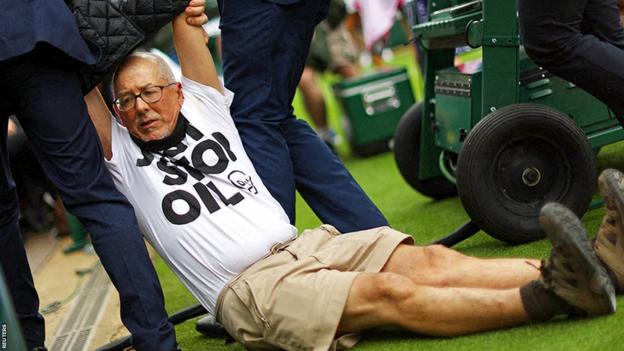 A protester is dragged away after a second disruption to play on Wimbledon's court 18