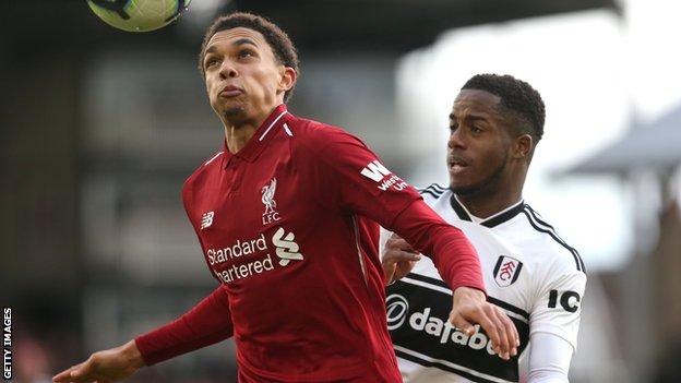 Liverpool defender Trent Alexander-Arnold heads the ball under pressure from Fulham's Ryan Sessegnon