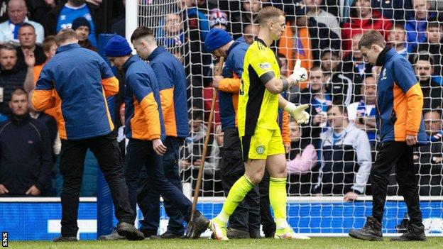 Ibrox ground staff removed glass from the pitch after Celtic goalkeeper Joe Hart alerted referee Willie Collum