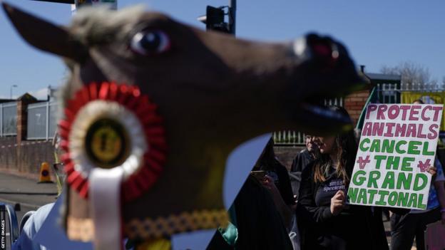 Protestors hold placards outside Aintree on Saturday morning