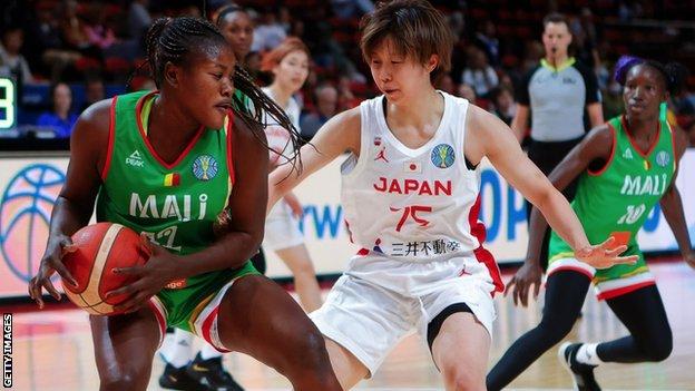 Alima Dembele of Mali looks to pass against Nanako Todo of Japan