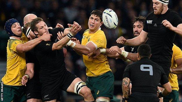 New Zealand's flanker and captain Richie McCaw is tackled by Australia's lock Dean Mumm