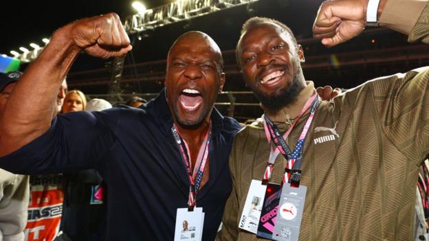 Terry Crews and Usain Bolt posing and smiling on the Las Vegas grid