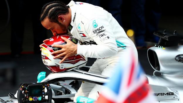Lewis Hamilton celebrates on his car as he wins the Chinese GP and the 1,000th race in the Formula 1