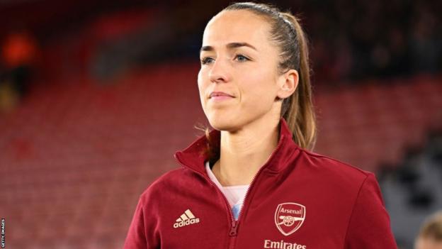 Lia Walti leads the Arsenal team out for a Women's Super League game