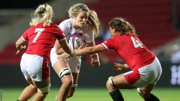 Zoe Aldcroft of England is tackled by Alex Callender and Natalia John of Wales