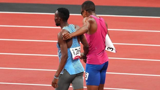 Botswana's Nijel Amos and Isaiah Jewell of USA help one another finish their 800m semi-final