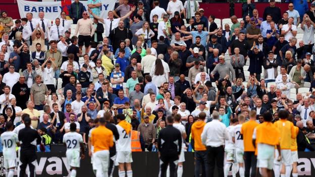 Leeds United players applauding the fans, who look dejected after their defeat by West Ham