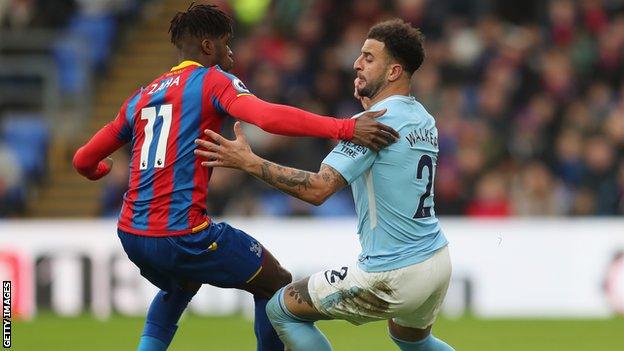 Kyle Walker (right) challenges Wilfried Zaha