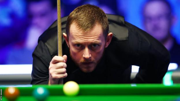 Mark Allen eyes up a shot during the World Grand Prix final against Judd Trump