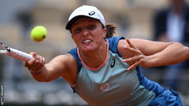 Iga Swiatek hits a return against Danka Kovinic in their French Open third-round match