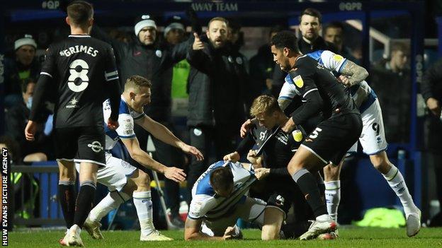 Flynn Downes became the first Swansea player to be sent off this season after tangling with Charlie Austin at a throw-in