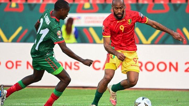 Guinea striker Jose Kante takes on the Malawi defence
