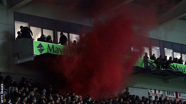 Flares are let off by away fans inside Brighton's Amex Stadium